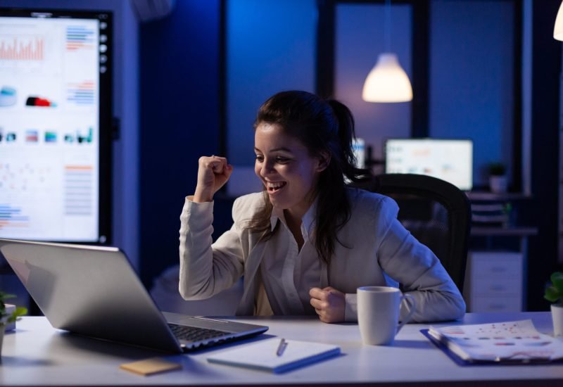 Stressed businesswoman checking profit resultes standing in business office late at night. Focused entrepreneur using technology network wireless for developing new marketing system